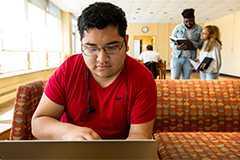 SEU student using laptop inside residence hall