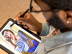 SEU graphic design student drawing on a tablet